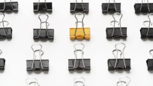 binder clips arranged with one gold one in the middle