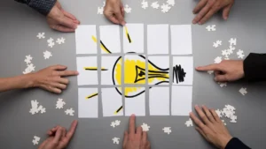 A group pieces together a drawing of a lightbulb to show the complete picture.